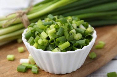 Kavanozda doğranmış yeşil soğan ve saplar masada, yakın plan.
