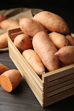 Tahta masadaki sandıkta taze çiğ patates, yakın plan.