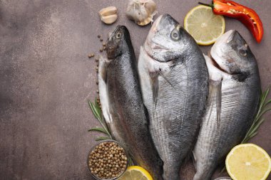 Deniz ürünleri. Kahverengi masa üzerinde farklı çiğ balık ve ürünler var. Metin için boşluk