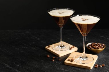 Bir bardak nefis espresso martini ve koyu dokulu kahve çekirdekleri. Metin için boşluk