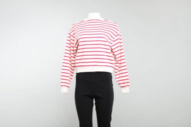 Hafif arka planda şık giyimli bir kadın mankeni.