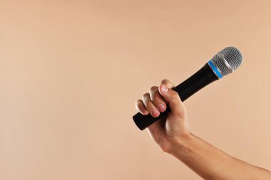 Bej arka planda mikrofonu olan adam, yakın plan. Metin için boşluk