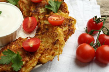 Lezzetli patatesli gözleme, ekşi krema, domates ve maydanoz masada, yakın plan.