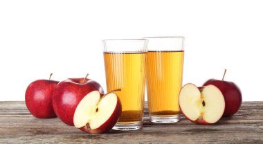 Bardakta elma suyu ve beyaz arka planda tahta masada taze meyve.