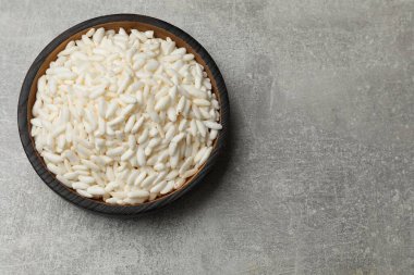 Puffed rice in bowl on light grey table, top view. Space for text clipart