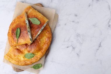 Peynirli ve fesleğenli leziz calzones beyaz mermer masa, üst manzara. Metin için boşluk