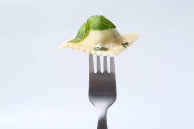 Peynirli ve fesleğenli lezzetli ravioli beyaz arka planda.