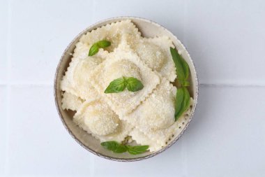 Peynirli ve fesleğenli nefis ravioli beyaz fayanslı masa, üst manzara