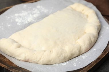 Tahtada pişmemiş calzone pizza, yakın plan.