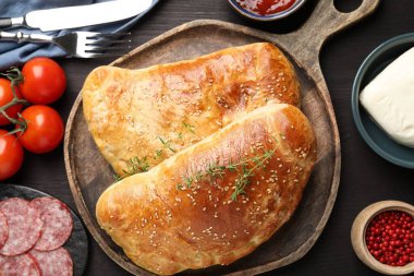 Tahta masada servis edilen leziz taze calzone pizzası.