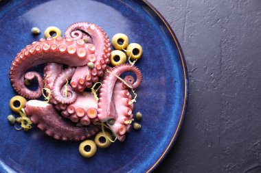 İştah açıcı ahtapot dokunaçları koyu masa, üst görünüm