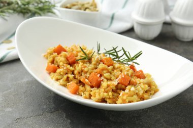 Delicious pumpkin risotto on grey table, closeup clipart