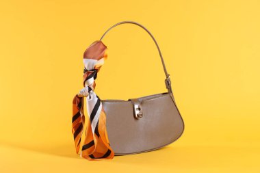 Sarı arka planda mendilli kahverengi deri çanta.