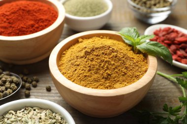 Ahşap masada farklı aromatik baharatlar, yakın plan.