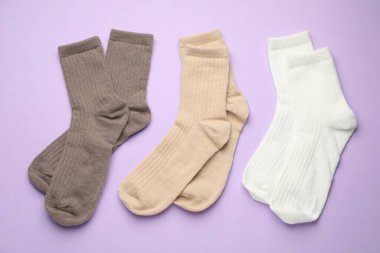 Menekşe arka planda farklı yumuşak çoraplar, düz yatış