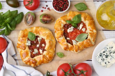 Beyaz ahşap masada domatesli, fesleğenli ve peynirli leziz galetler.