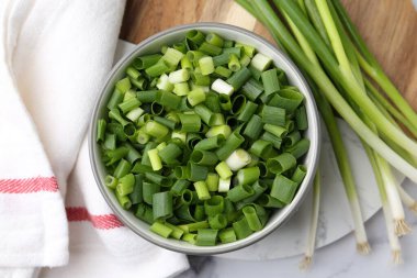Kasede doğranmış yeşil soğan ve sapları beyaz mermer masa, üst manzara
