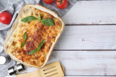 Hafif ahşap masada servis edilen fesleğenli nefis pişmiş lazanya. Metin için boşluk