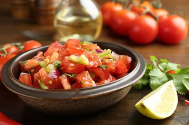 Ahşap masadaki malzemelerle nefis baharatlı salsa sosu. Yakın plan.