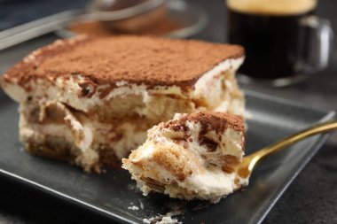 Siyah masada lezzetli tiramisu yiyorum, yakın plan.