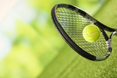 Tenis raketi, yeşil çimlerin üzerinde top, yakın plan. Metin için boşluk