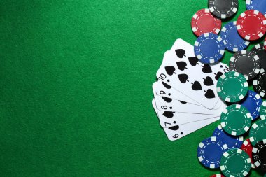 Yeşil masada kağıt ve poker fişleri, düz yatış. Metin için boşluk