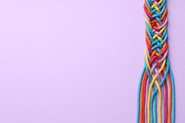 Renkli ipler menekşe arkaplan, üst görünüm ve metin için boşluk üzerine bağlanmış. Birlik kavramı