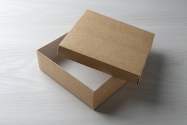 Beyaz ahşap arka planda açık bir karton kutu. Tasarım için model