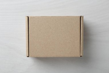 Beyaz ahşap arka planda boş bir karton kutu, üst manzara. Tasarım için model