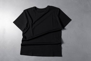 Gri desenli arka planda bir tişört, üst görünümde.