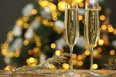 Gözlüklü şampanya ve masanın üstünde bulanık Noel ışıklarına karşı dekor, mesaj için yer. Bokeh etkisi