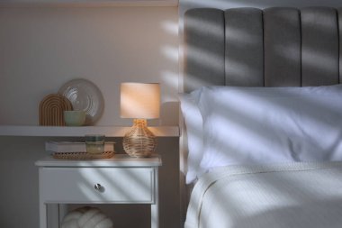 Şık bir oturma odası. Yatağı, yatağı ve lambası var.