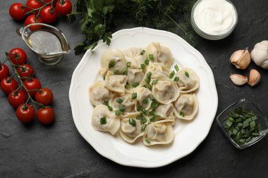 Gri desenli masada servis edilen yeşil soğanlı leziz pelmeni.