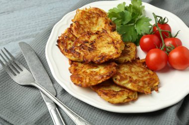 Gri ahşap masada servis edilen domatesli ve maydanozlu patatesli gözleme.