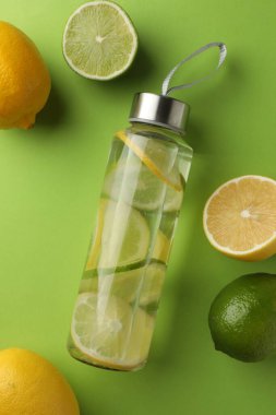 Limonlu limonlu su ve açık yeşil arka planda taze meyve, düz yatıyordu.