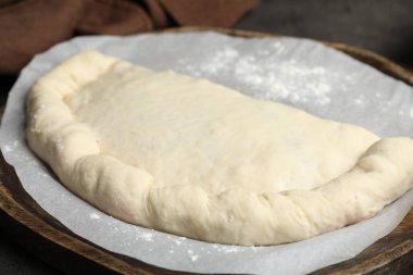 Tahtada pişmemiş calzone pizza, yakın plan.