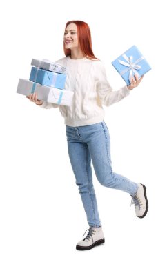 Beyaz arka planda Noel hediyeleri olan kazaklı genç bir kadın.