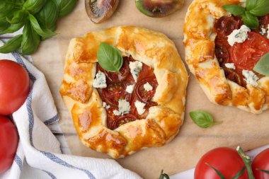 Beyaz ahşap masada domatesli, fesleğenli ve peynirli leziz galetler.