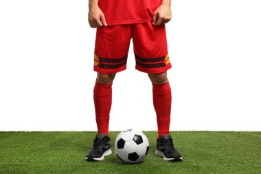 Beyazların arka planına karşı suni çimlerde futbol topu taşıyan futbolcu, yakın plan