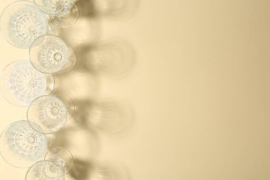 Boş şarap kadehleri bej arka planda güzel gölgeler bırakıyor. Metin için boşluk