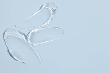 Açık mavi arka planda kozmetik ürünü örnekleri, üst görünüm. Metin için boşluk