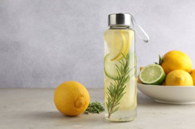Biberiyeli limonlu su ve gri masada taze meyve, mesaj için yer var.