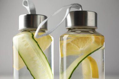 Açık gri arka planda salatalıklı limonlu su, yakın plan.