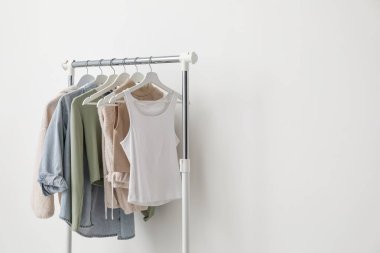 Beyaz duvarın yanında farklı kıyafetlerle dizilin. Metin için boşluk