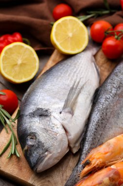 Taze çiğ deniz ürünleri ve ahşap masadaki ürünler, yakın plan.