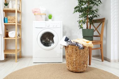 Banyoda yerde çamaşır dolu bir sepet.