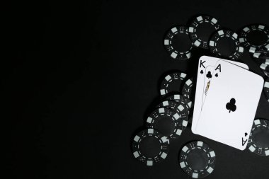 Siyah masada kağıt ve poker fişleri, düz yatış. Metin için boşluk