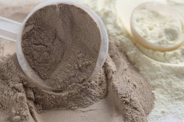 Protein tozu ve kepçeleri yığını, yakın plan.