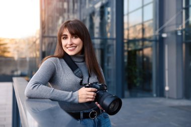 Binanın yakınında dijital kamerası olan profesyonel bir fotoğrafçı.