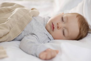 Evdeki yatakta uyuyan tatlı bir bebek.